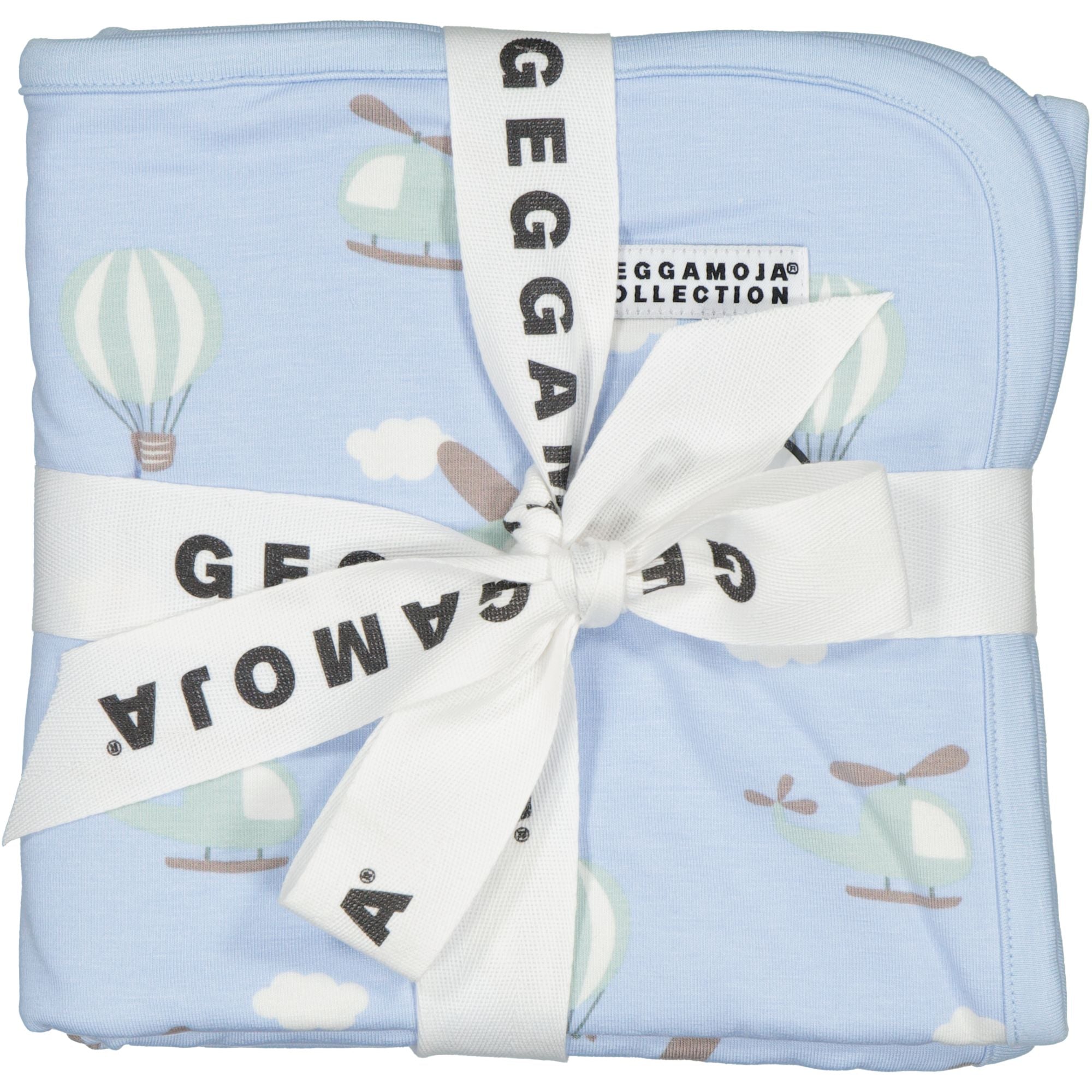 Helligblaue Babydecke aus weicher Bambusmischung mit Flugzeug- und Heißluftballon-Muster, gebunden mit einem weißen Geggamoja-Band.